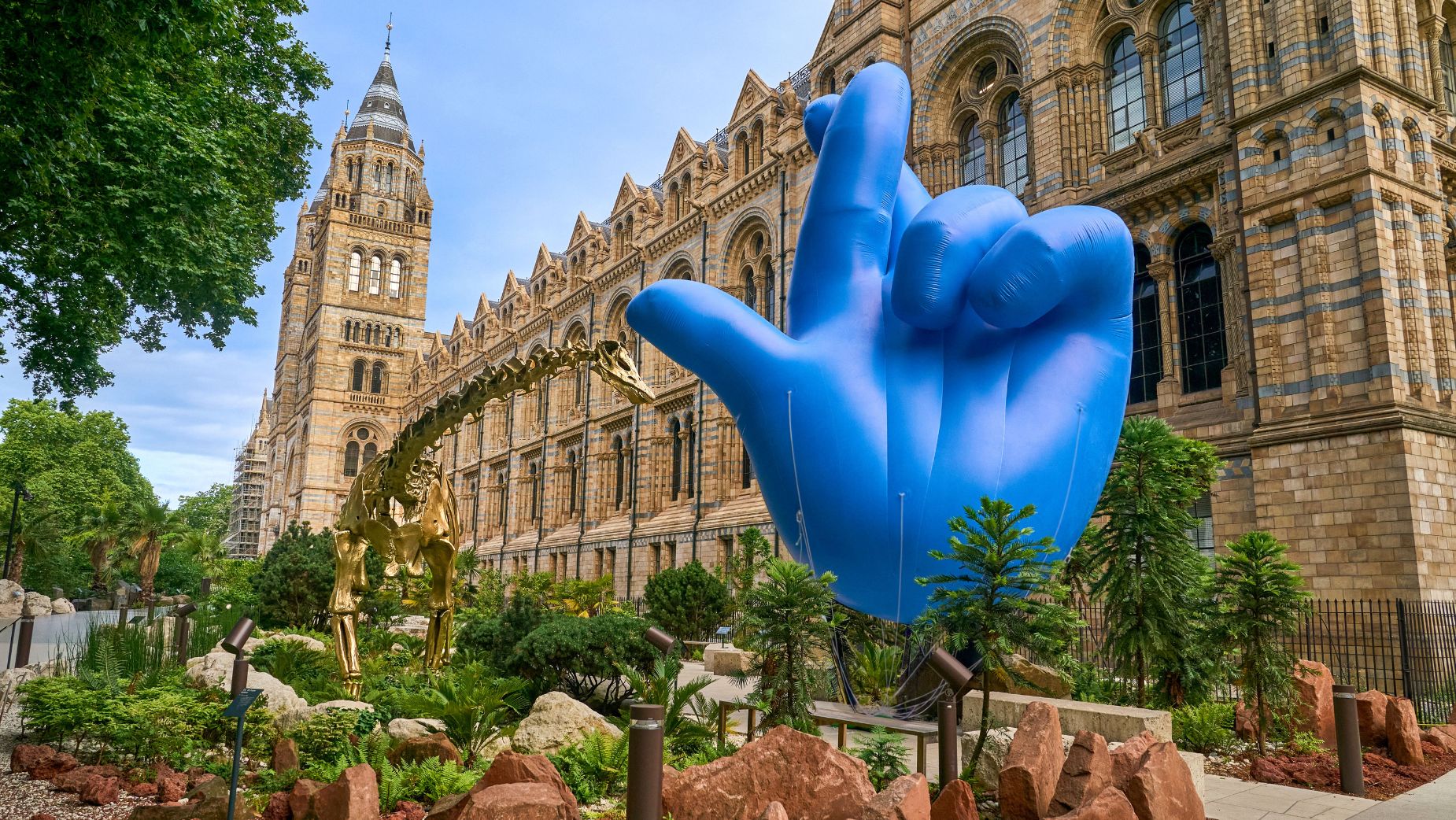 Giant blue balloon sculpture of crossed fingers outside the natural history museum